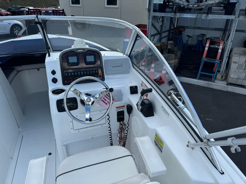 Slide: The Image of 2014 Sea Hunt Escape 235 SE boat cockpit with steering wheel and navigation controls. - 3