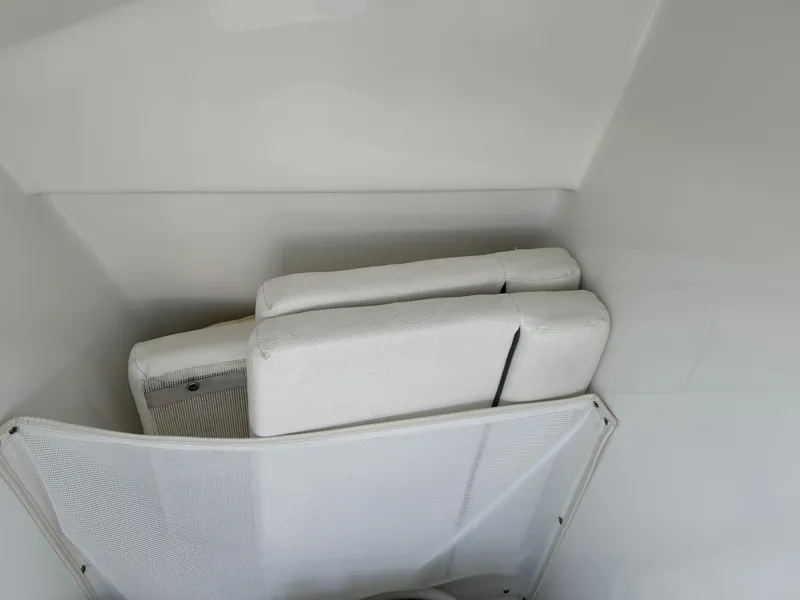 Slide: The Image of 2014 Sea Hunt Escape 235 SE boat interior with white cushions and mesh storage. - 9