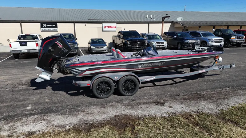 Slide: The Image of 2025 Phoenix 921 ELITE boat on trailer in parking lot, surrounded by vehicles. - 16