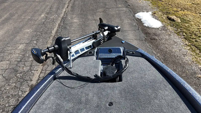 Slide: The Image of 2025 Phoenix 921 ELITE boat deck with mounted trolling motor on a paved surface. - 20