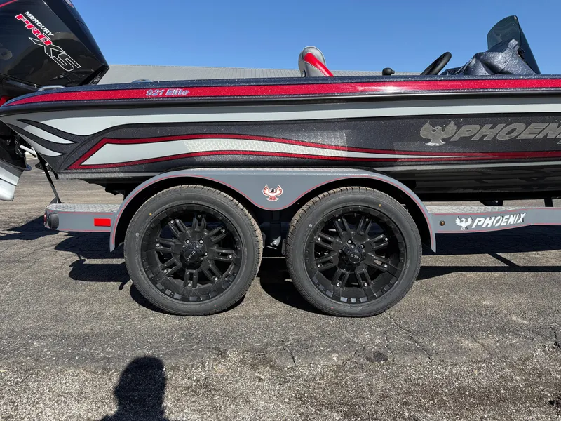 Slide: The Image of 2025 Phoenix 921 ELITE boat on trailer with black wheels, red and gray detailing. - 21