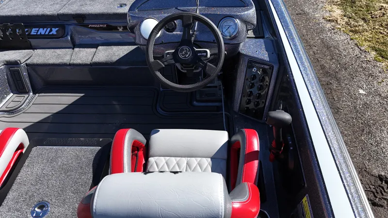 Slide: The Image of 2025 Phoenix 921 ELITE boat interior with steering wheel and red-accented seats. - 3