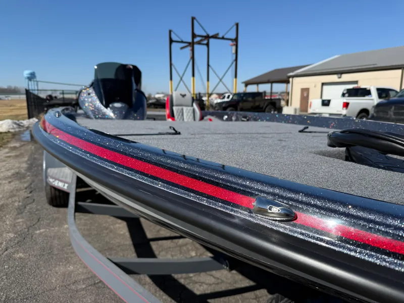 Slide: The Image of 2025 Phoenix 921 ELITE boat with sleek design and metallic finish, parked outdoors. - 9