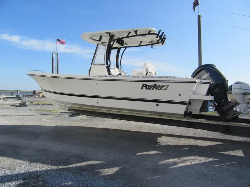 The Image of 2025 Parker 2400 Center Console boat on trailer, American flag, clear sky. - 1