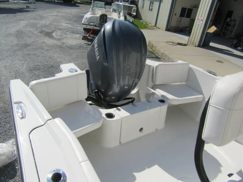 Slide: The Image of 2025 Parker 2400 Center Console boat with Yamaha outboard motor, docked near a building. - 16