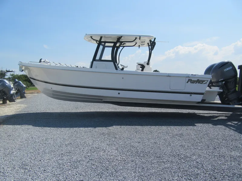 The Image of 2025 Parker 2900 Center Console boat on gravel, featuring Yamaha engines, under clear blue sky. - 2