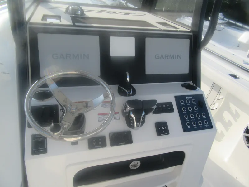 Slide: The Image of 2025 Parker 2900 Center Console boat dashboard with Garmin displays and steering wheel. - 9