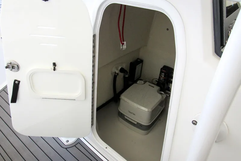 Slide: The Image of 2018 Crevalle 26 Bay boat storage compartment with portable toilet and equipment. - 48