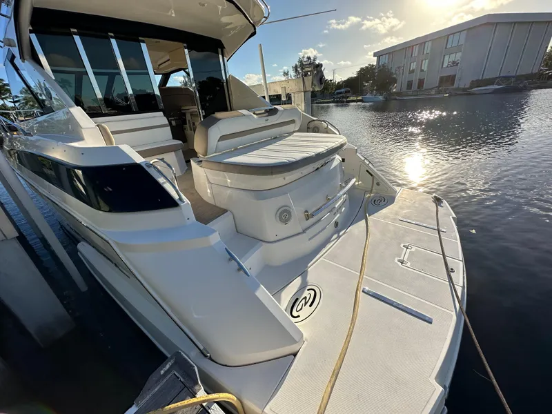 Slide: The Image of 2017 Regal 42 Sport Coupe yacht docked by the water at sunset. - 16