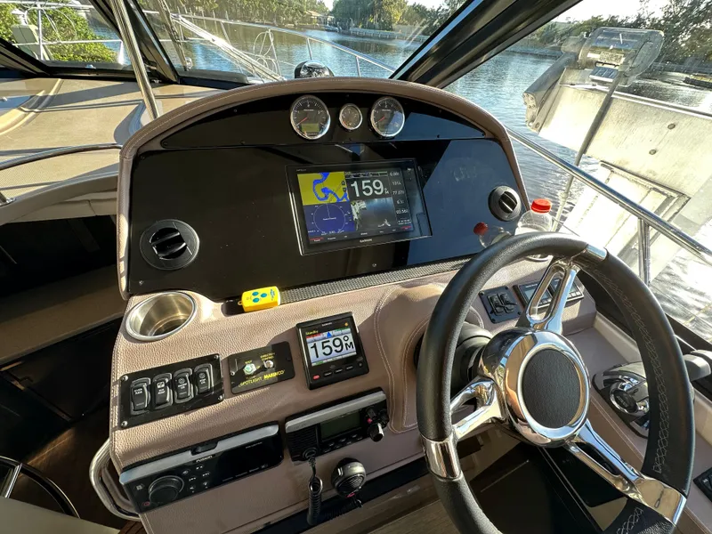 Slide: The Image of 2017 Regal 42 Sport Coupe dashboard with navigation system and steering wheel, docked by the water. - 4