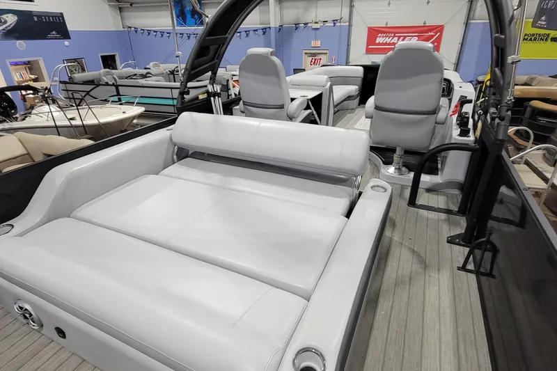 Slide: The Image of 2022 Bentley Pontoons Elite 253 Swingback interior with luxurious seating in showroom. - 7