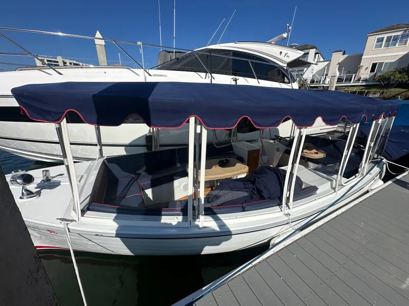 Slide: The Image of 2021 Duffy Bay Island boat docked with blue canopy and seating area. - 1