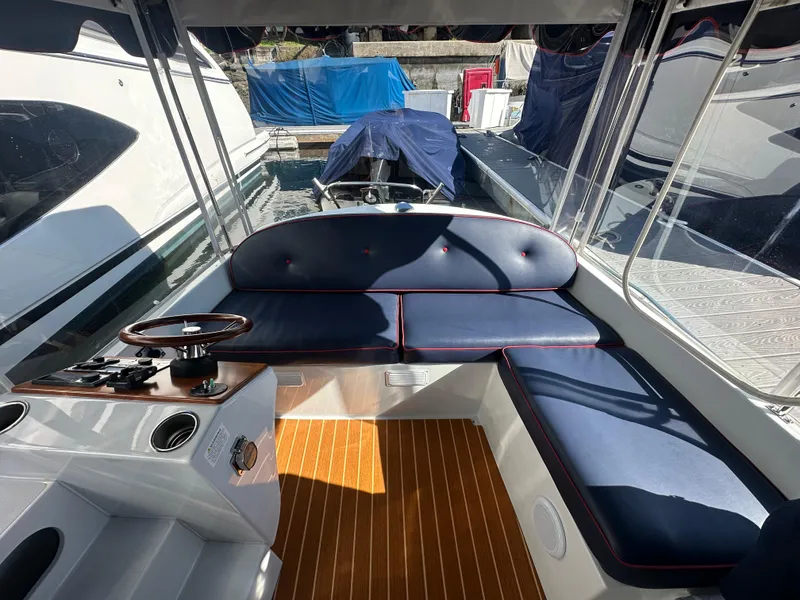 Slide: The Image of Interior of 2021 Duffy Bay Island boat with blue seating and wooden flooring. - 2