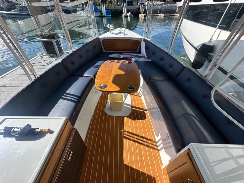 Slide: The Image of 2021 Duffy Bay Island boat interior with cushioned seating and wooden table. - 4
