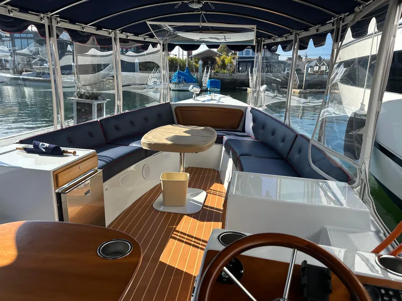 Slide: The Image of 2021 Duffy Bay Island boat interior with seating, table, and waterfront view. - 7