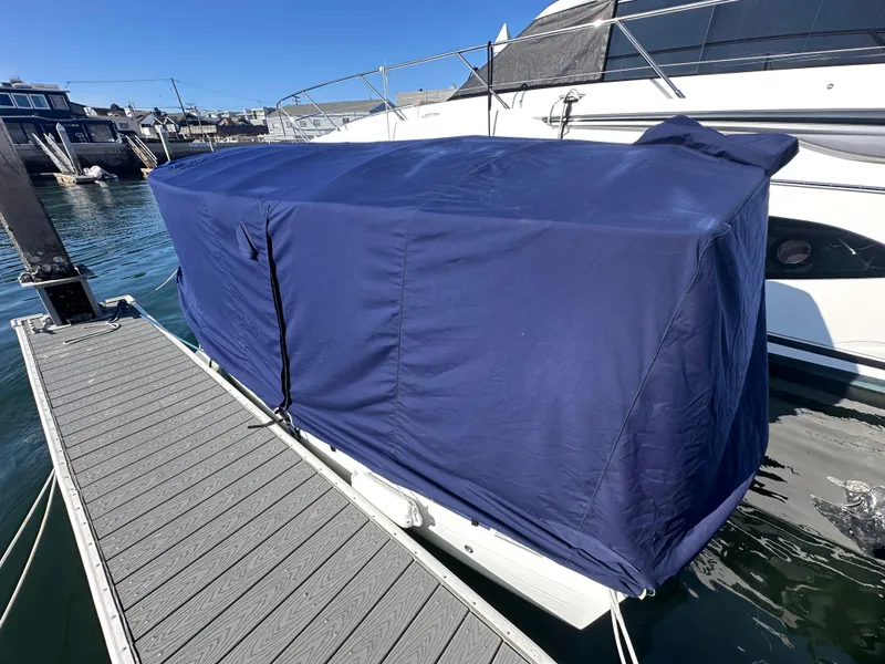 Slide: The Image of Covered 2021 Duffy Bay Island boat docked, blue tarp, sunny day, marina background. - 8