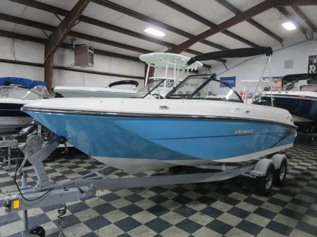 The Image of 2023 Bayliner 210EL boat in showroom, blue hull, on trailer. - 1