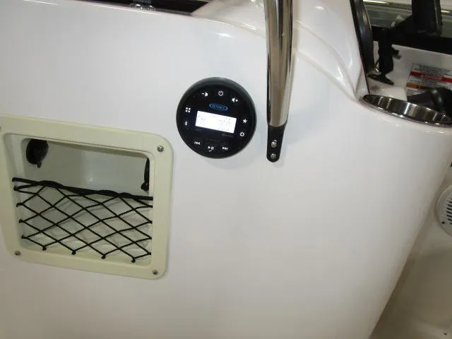 Slide: The Image of 2023 Bayliner 210EL boat interior with control panel and storage compartment. - 12