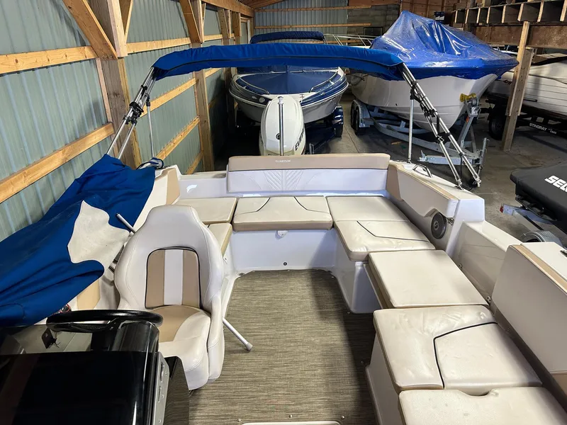Slide: The Image of 2019 Glastron GTD 180 boat interior with seating, stored in a wooden shed. - 12