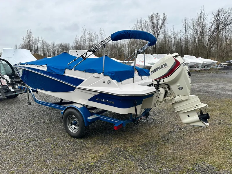 Slide: The Image of 2019 Glastron GTD 180 boat with blue cover and Evinrude motor on trailer. - 2