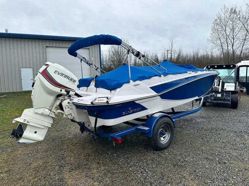 Slide: The Image of 2019 Glastron GTD 180 boat with Evinrude outboard motor on trailer, blue cover. - 3