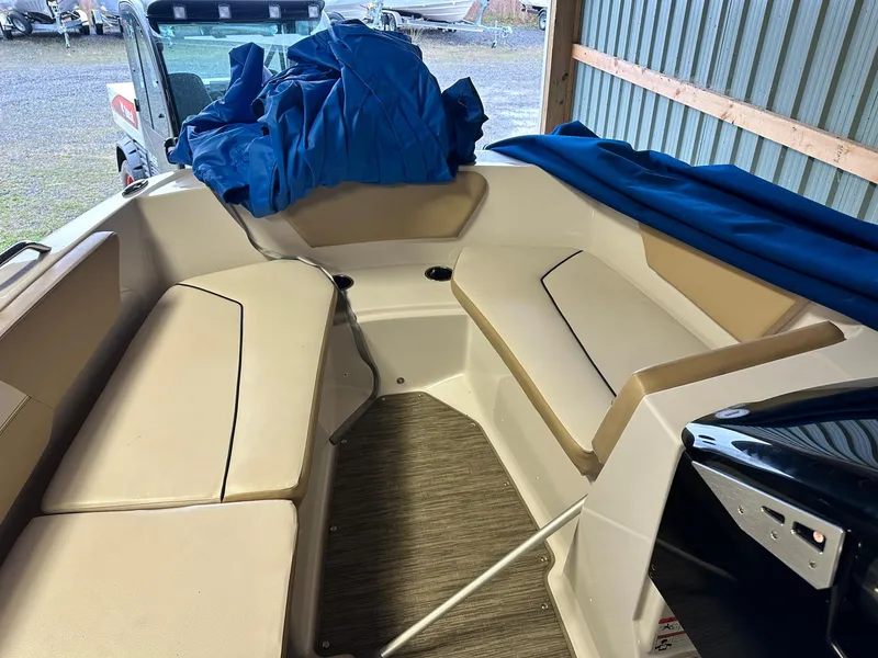 Slide: The Image of 2019 Glastron GTD 180 boat interior with beige seating and blue cover. - 7