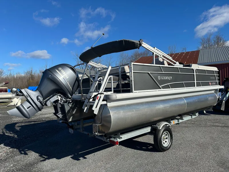 Slide: The Image of 2023 Godfrey SWEETWATER 2286 SFL pontoon boat on trailer, parked outdoors. - 3