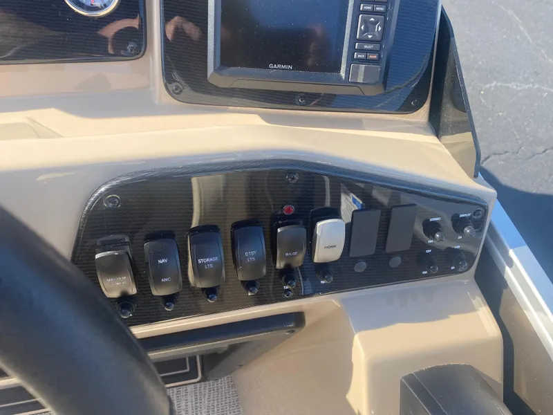 Slide: The Image of Control panel of 2025 SunCatcher Select 322RC boat with switches and Garmin display. - 12