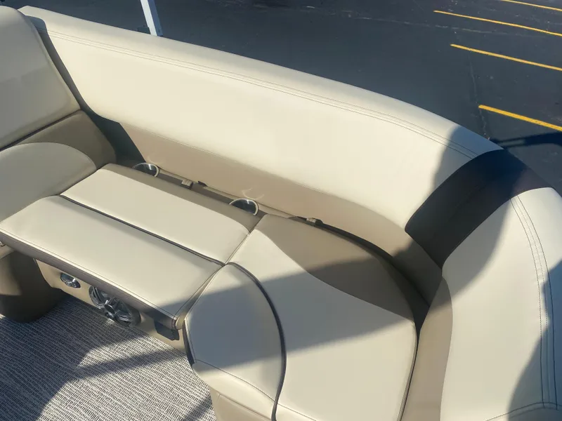 Slide: The Image of 2025 SunCatcher Select 322RC boat interior with beige seating and cup holders. - 15