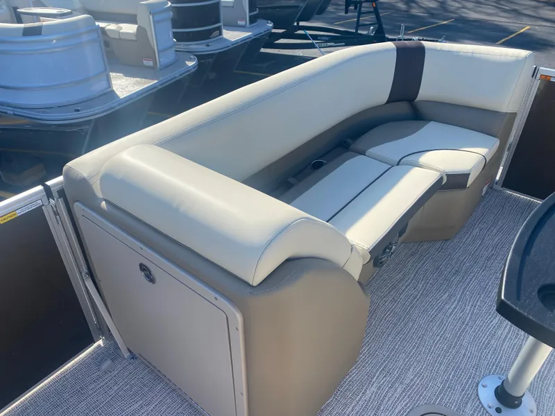 Slide: The Image of 2025 SunCatcher Select 322RC boat seating with beige upholstery and storage compartment. - 17