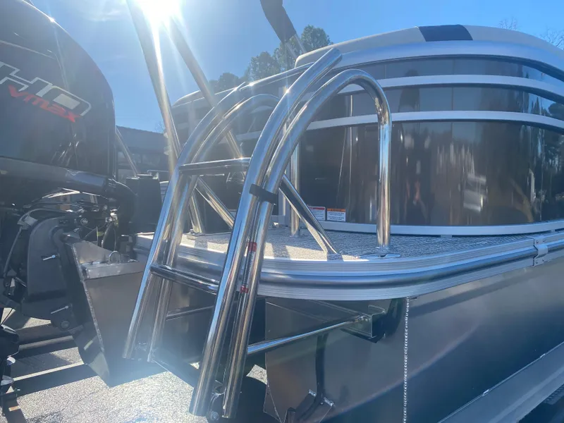 Slide: The Image of 2025 SunCatcher Select 322RC boat with shiny metal ladder and motor, under bright sunlight. - 19