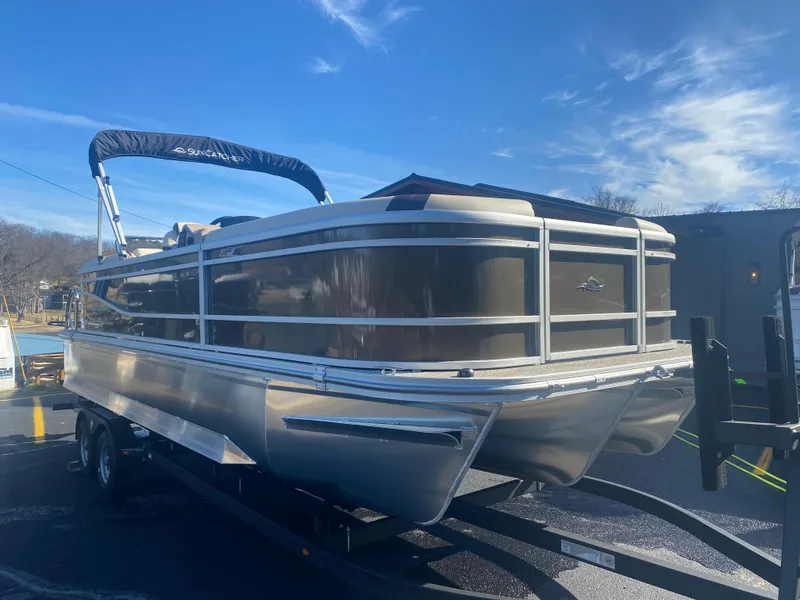 Slide: The Image of 2025 SunCatcher Select 322RC pontoon boat on trailer under clear blue sky. - 2