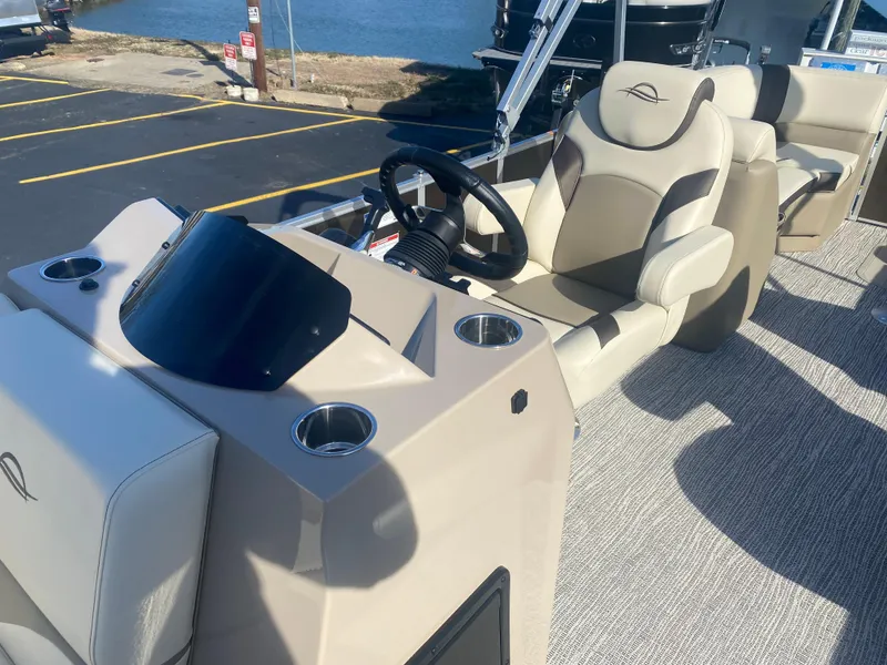 Slide: The Image of 2025 SunCatcher Select 322RC boat interior with steering wheel and seating. - 7