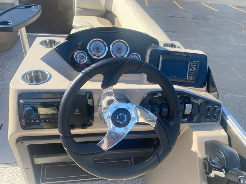 Slide: The Image of 2025 SunCatcher Select 322RC boat dashboard with steering wheel and navigation controls. - 9