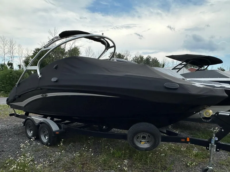 Slide: The Image of 2012 Yamaha Boats 242 Limited S covered on trailer, parked outdoors. - 20