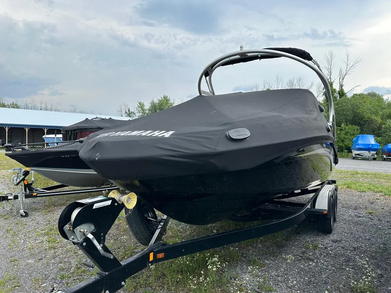 Slide: The Image of 2012 Yamaha Boats 242 Limited S covered on trailer, parked outdoors. - 5