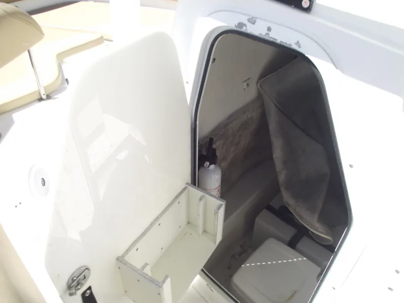 Slide: The Image of 2012 Sea Hunt Ultra 211 boat storage compartment with open door and visible interior. - 19