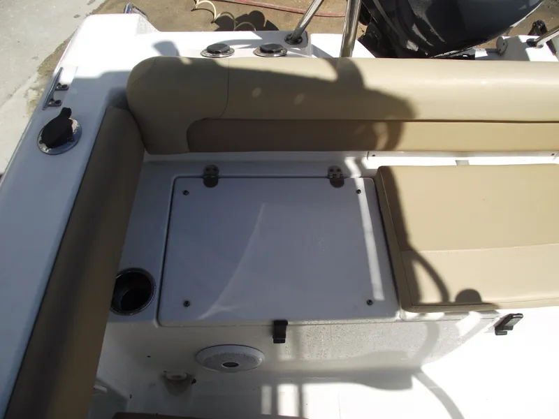 Slide: The Image of 2012 Sea Hunt Ultra 211 boat interior with beige seating and storage compartment. - 32