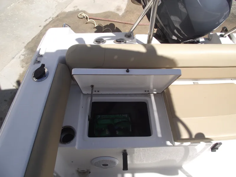 Slide: The Image of 2012 Sea Hunt Ultra 211 boat interior with open storage compartment and beige seating. - 33