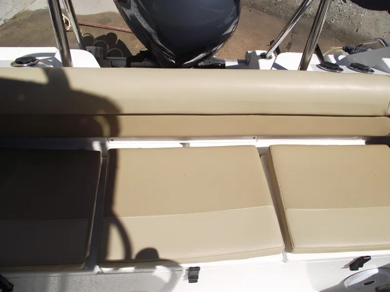 Slide: The Image of 2012 Sea Hunt Ultra 211 boat seating area with beige cushions and motor in background. - 34