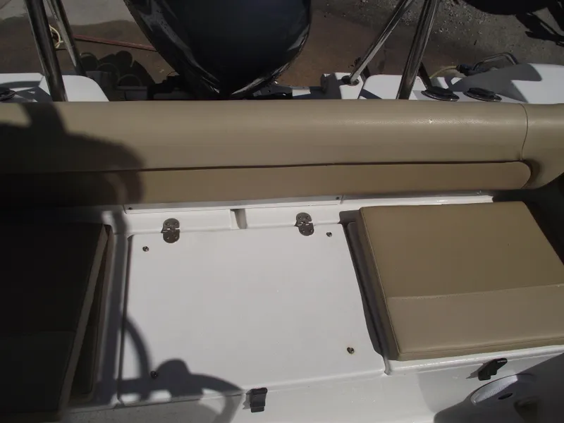 Slide: The Image of 2012 Sea Hunt Ultra 211 boat seating area with beige cushions and storage compartments. - 35