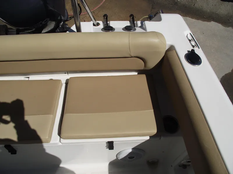 Slide: The Image of 2012 Sea Hunt Ultra 211 boat seating area with beige cushions and rod holders. - 37