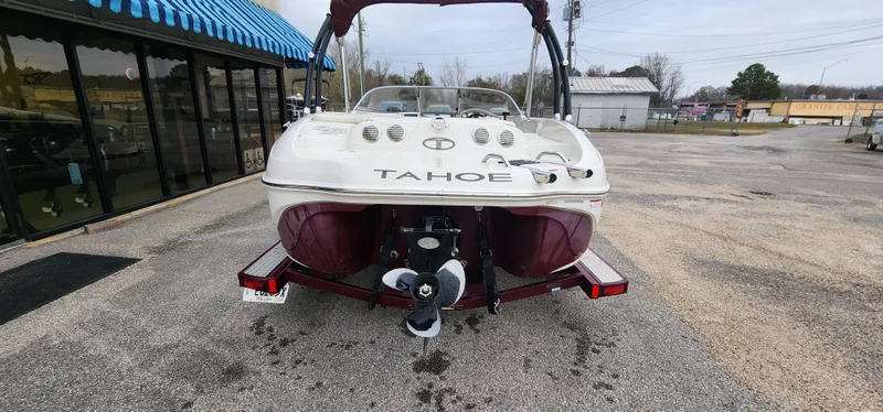 Slide: The Image of 2014 Tahoe Q5i boat on trailer, parked outside a building with blue awning. - 10
