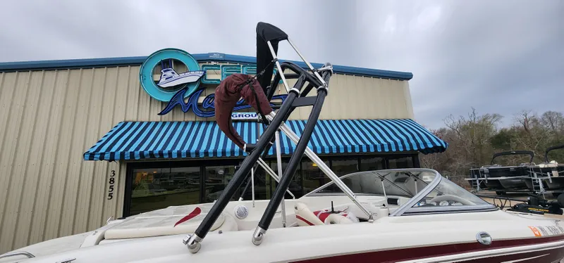 Slide: The Image of 2014 Tahoe Q5i boat parked outside a marine dealership with blue-striped awning. - 3
