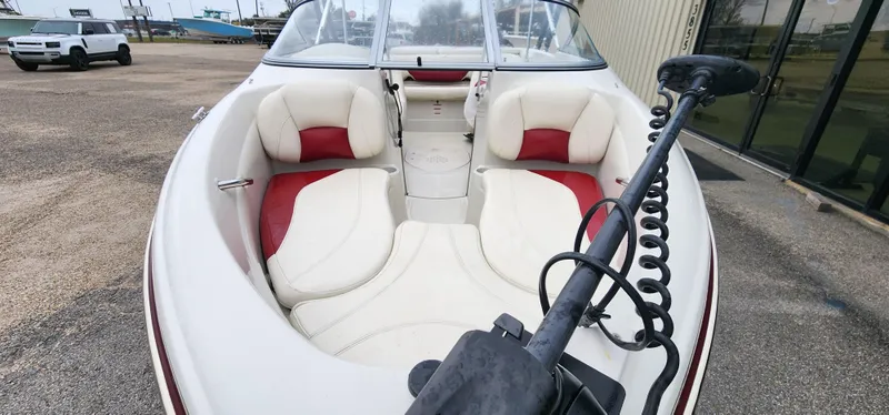 Slide: The Image of 2014 Tahoe Q5i boat interior with white and red seating, featuring a trolling motor. - 6