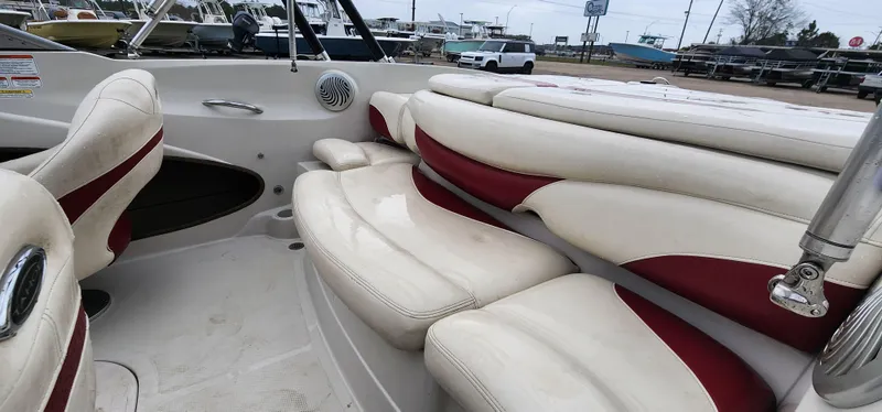 Slide: The Image of 2014 Tahoe Q5i boat interior with white and red seating, parked in a marina. - 7