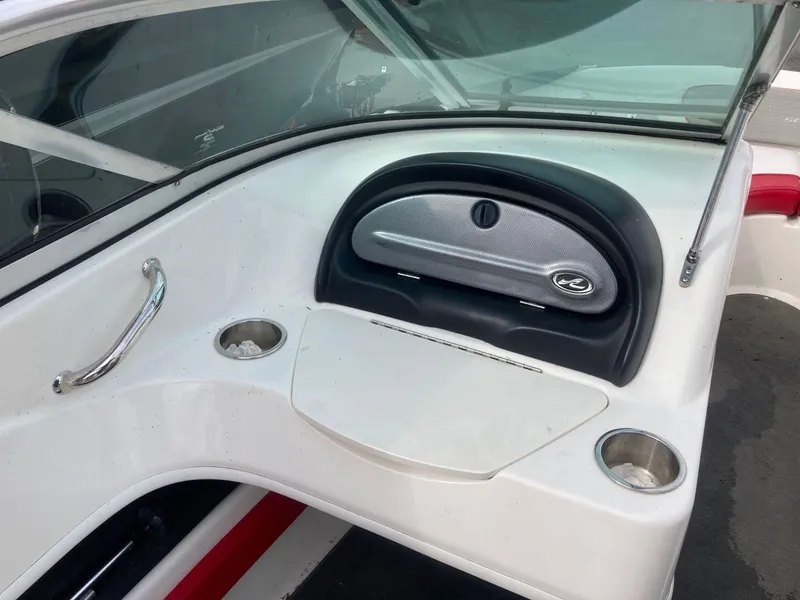 Slide: The Image of Interior of a 2011 Sea Ray 205 Sport boat, featuring cup holders and a storage compartment. - 9