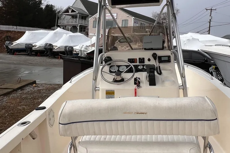 Slide: The Image of 2003 Sea Hunt Triton 202 boat interior with steering console and covered boats in background. - 5