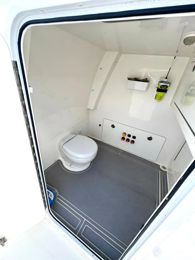Slide: The Image of Interior of 2022 Invincible 33 Catamaran bathroom with toilet and storage. - 12