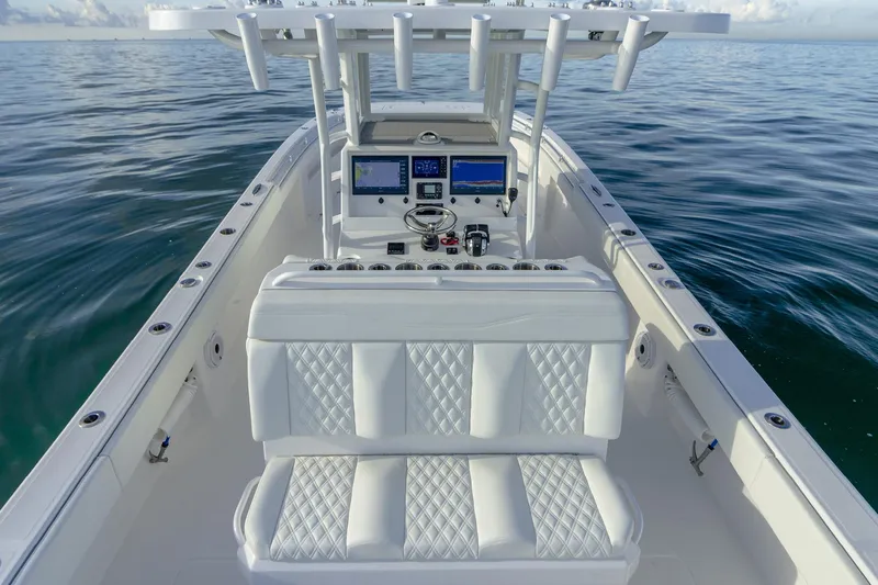 Slide: The Image of 2022 Invincible 33 Catamaran interior with modern dashboard and seating on calm water. - 14